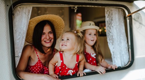 Illustrasjonsfoto: Mor med to barn ser ut av vinduet på en campingvogn.