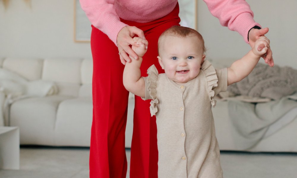 Illustrasjonsfoto: En mor leier babyen sin i stua.