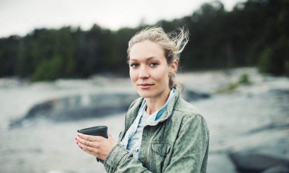 Illustrasjonsfoto: En ung kvinne står utendørs med en turkopp i hendene.