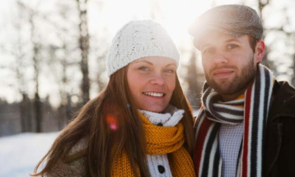Mann og dame som står ute i snøen om vinteren.